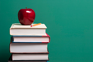 Image of books piled up with an apple on top